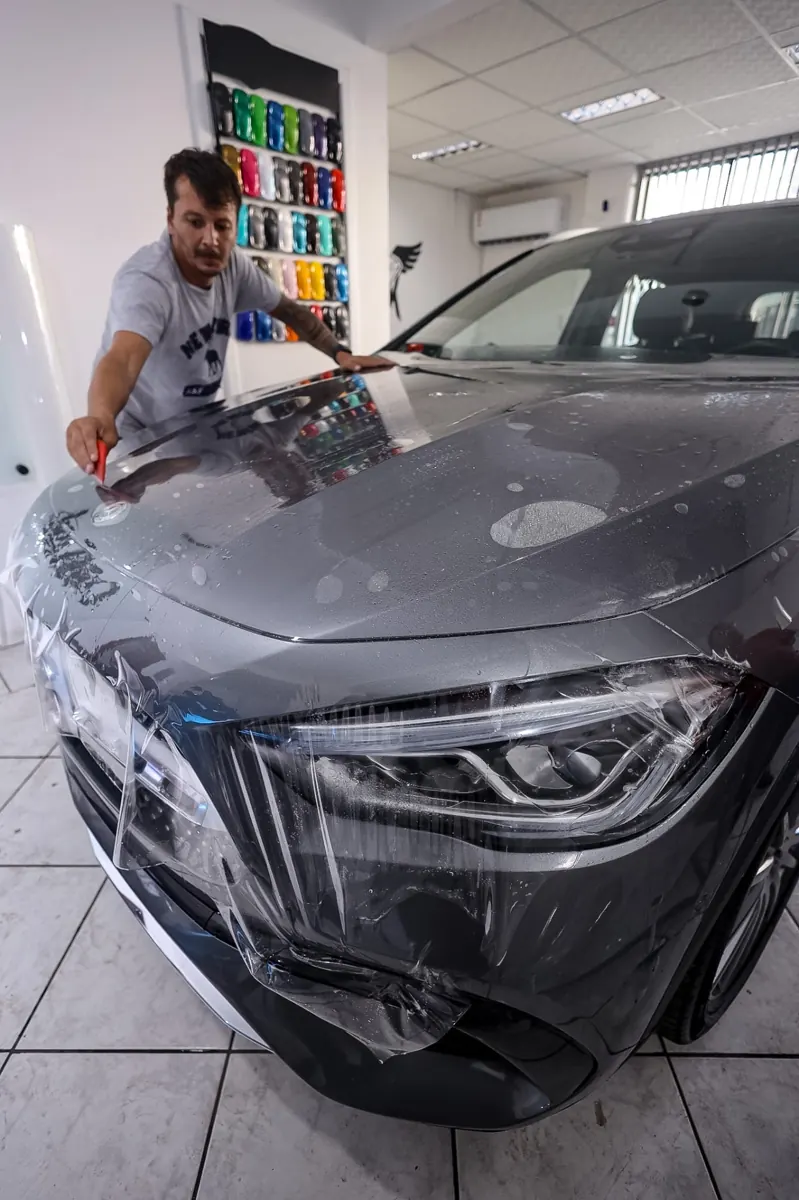 Instalador da MK Films aplicando PPF no capô de Mercedes-Benz